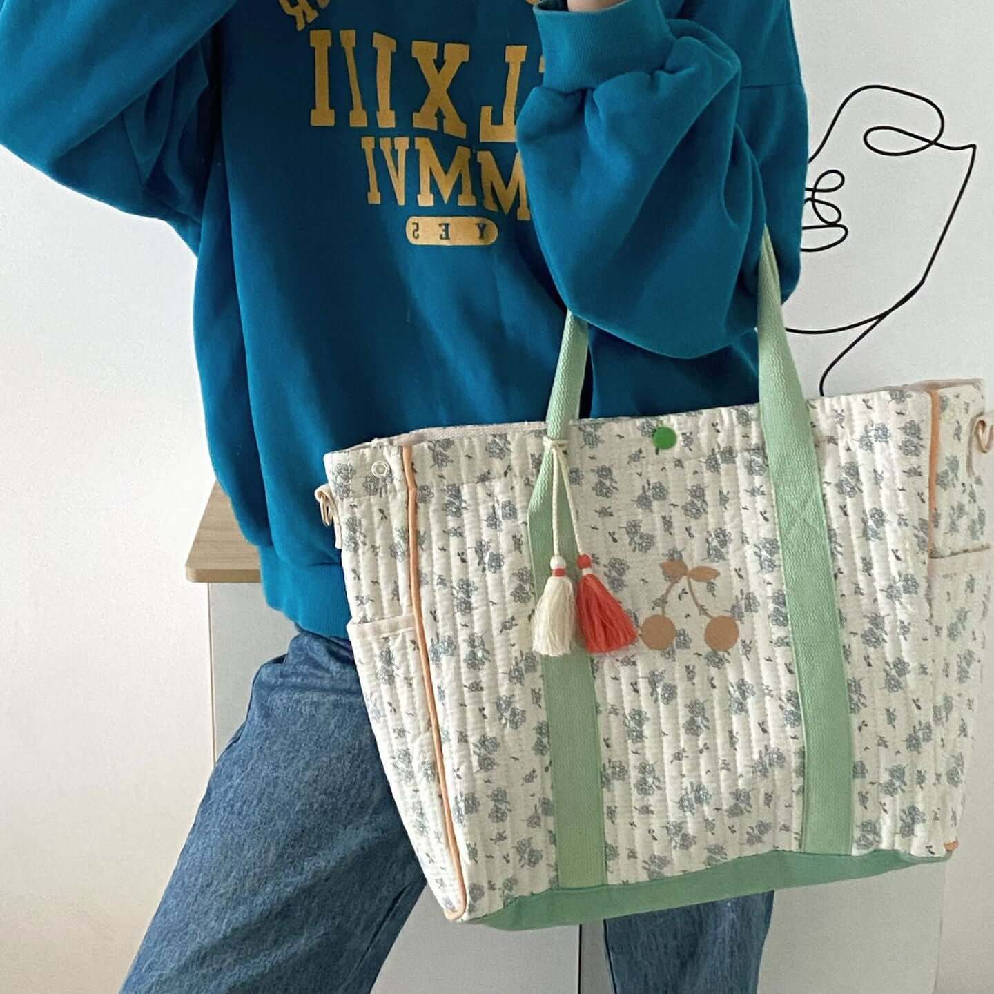 Large capacity floral cherry embroidered mommy bag with tassels and floral design.