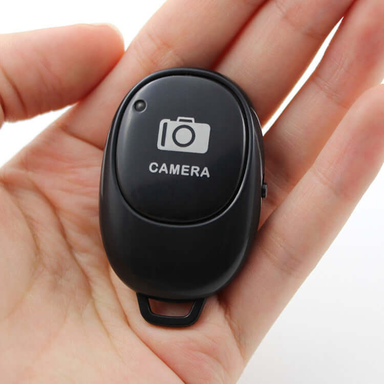 Multifunctional bluetooth remote for selfies held in hand, perfect for capturing moments with ease.