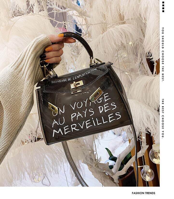 Stylish jelly shoulder bag in transparent design with unique lettering, held by a model against a chic background.