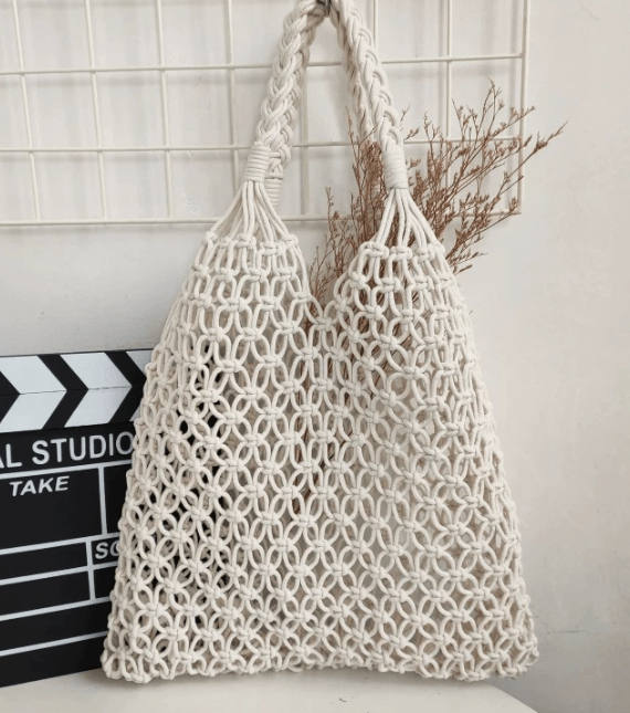 Stylish woven straw bags, featuring a chic bucket design in cream color for versatile fashion.