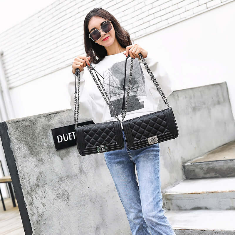 A woman modeling a stylish chain bag, crossbody bag, shoulder bag in black, showcasing its chic design and functionality.