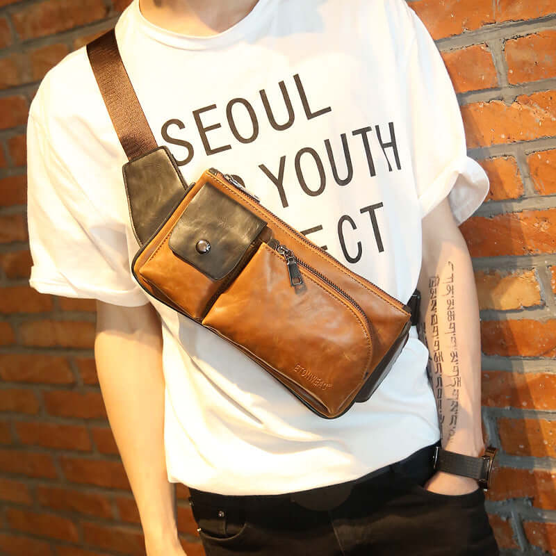 Shoulder Bag, Chest Bag, Crossbody Bag in brown leather style worn on a person against a brick wall.