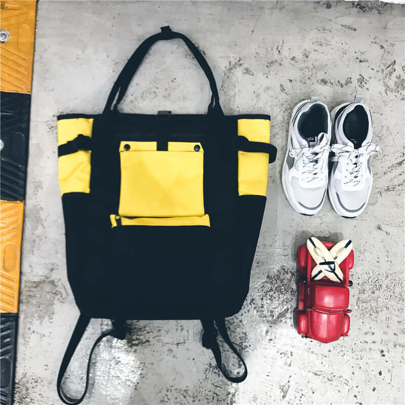 Trendy Canvas Backpack in black and yellow color combination with sneakers and red roller skates on the side.