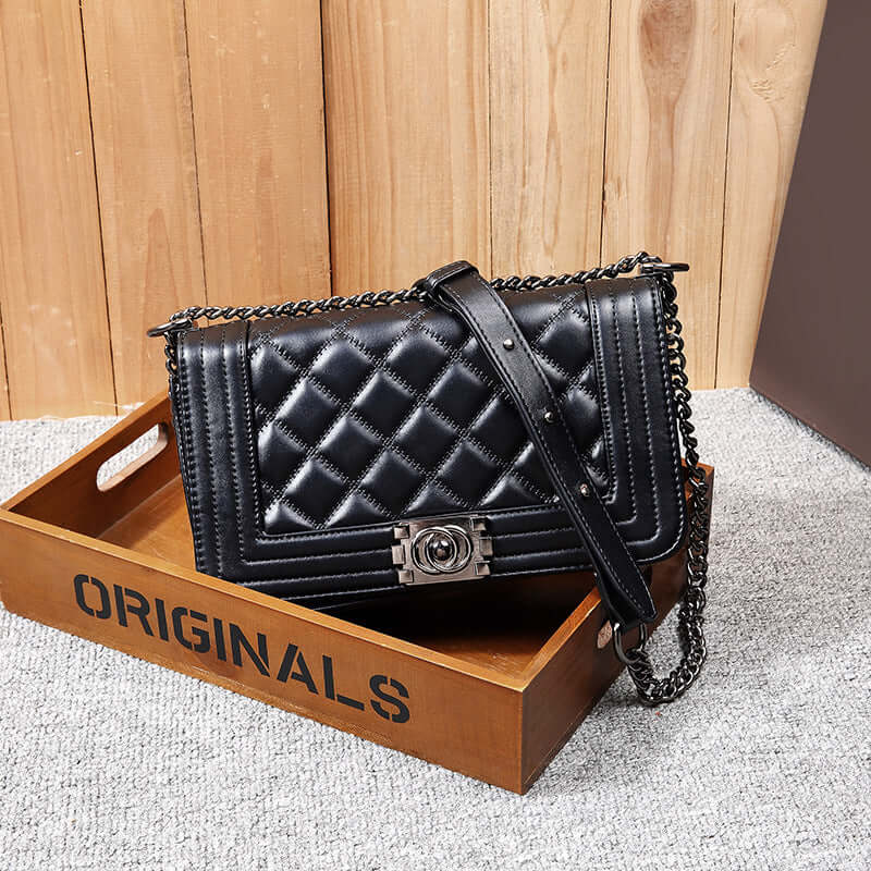 Chain Bag, Crossbody Bag, Shoulder Bag placed on a wooden tray with a stylish design in black leather.