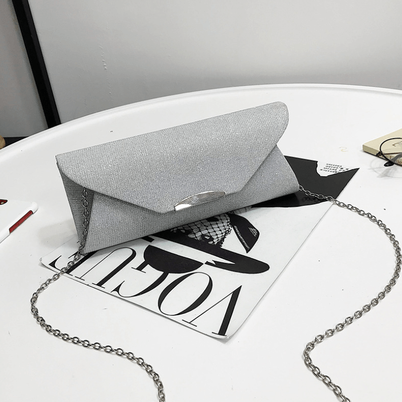Stylish evening clutch bag in silver with chain design, perfect for parties and special occasions.