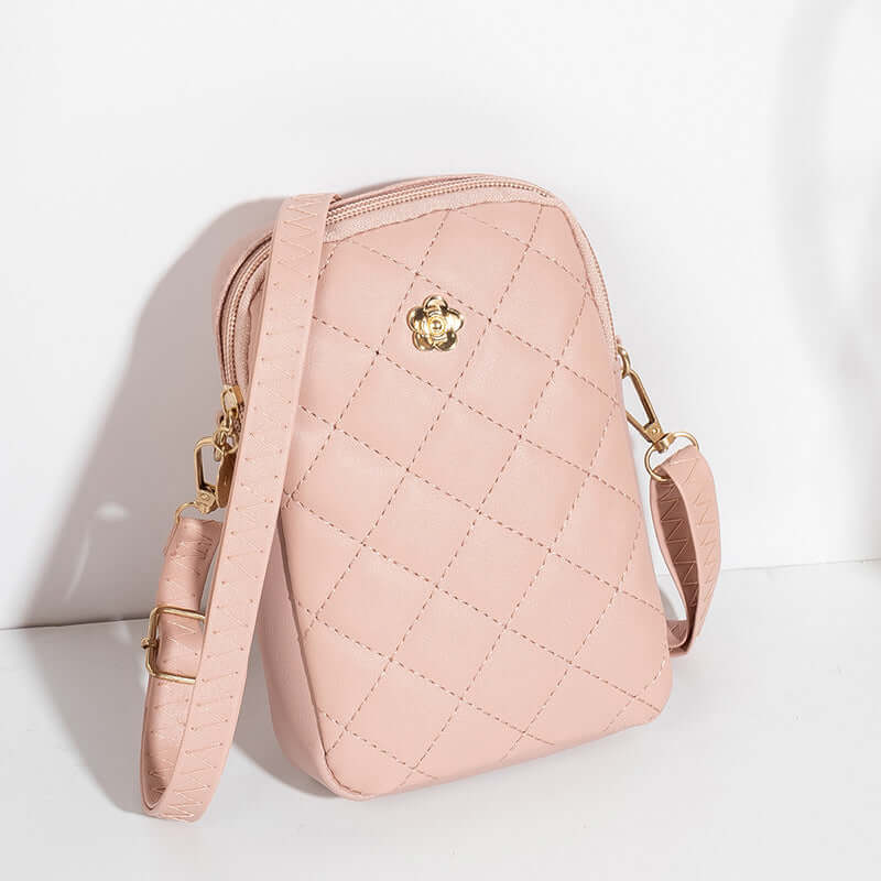 Embroidered women's crossbody bag in soft pink with quilted design, perfect for travel and commuting.