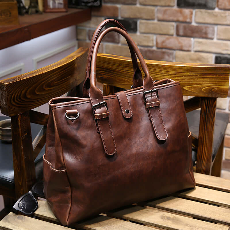 Vintage men's crossbody bag displayed on a wooden table with a rustic background featuring brown PU leather design.