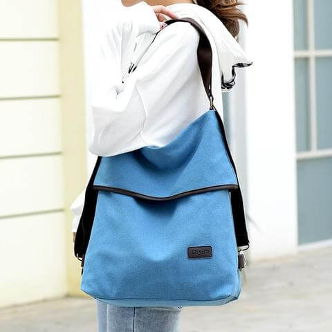 Versatile canvas women's bag showcased as a stylish crossbody backpack in blue, perfect for modern fashion.
