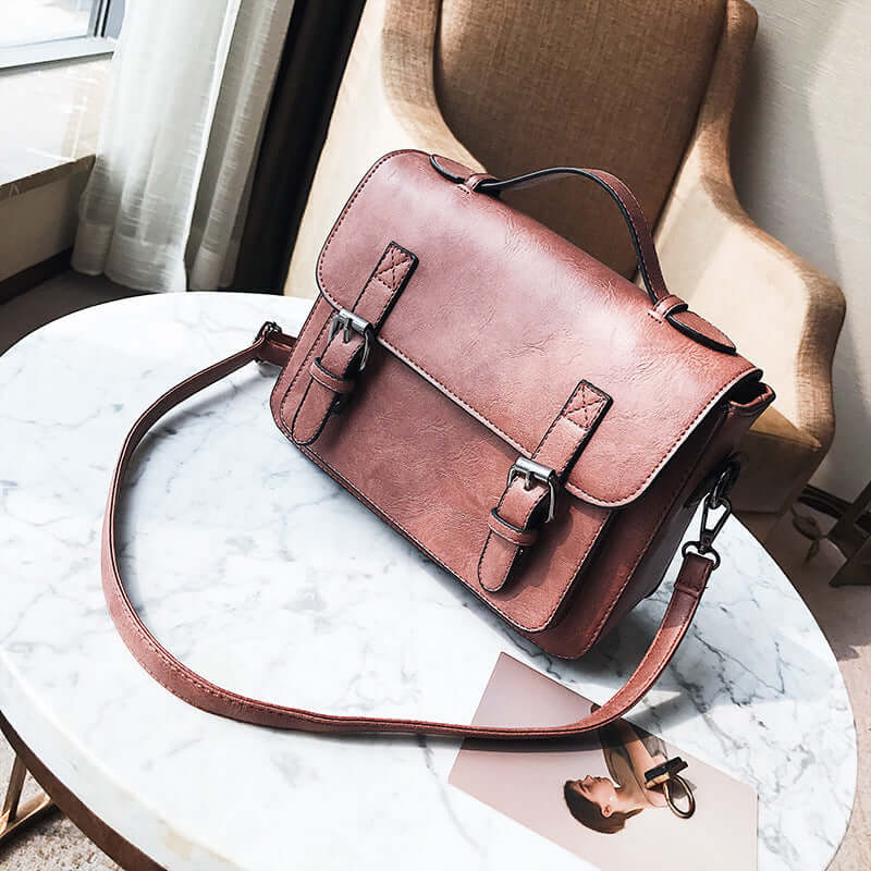 Stylish commuter messenger bag made of high-quality PU fabric, resting on a marble table.
