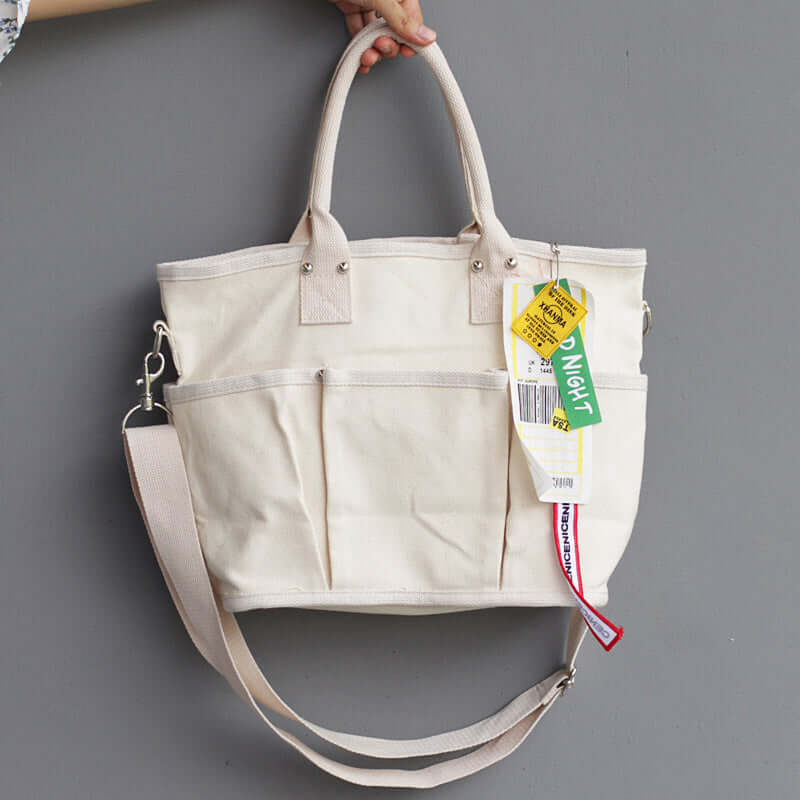 Stylish shoulder tote bag featuring a cream color, dual handles, and adjustable shoulder strap for versatility.