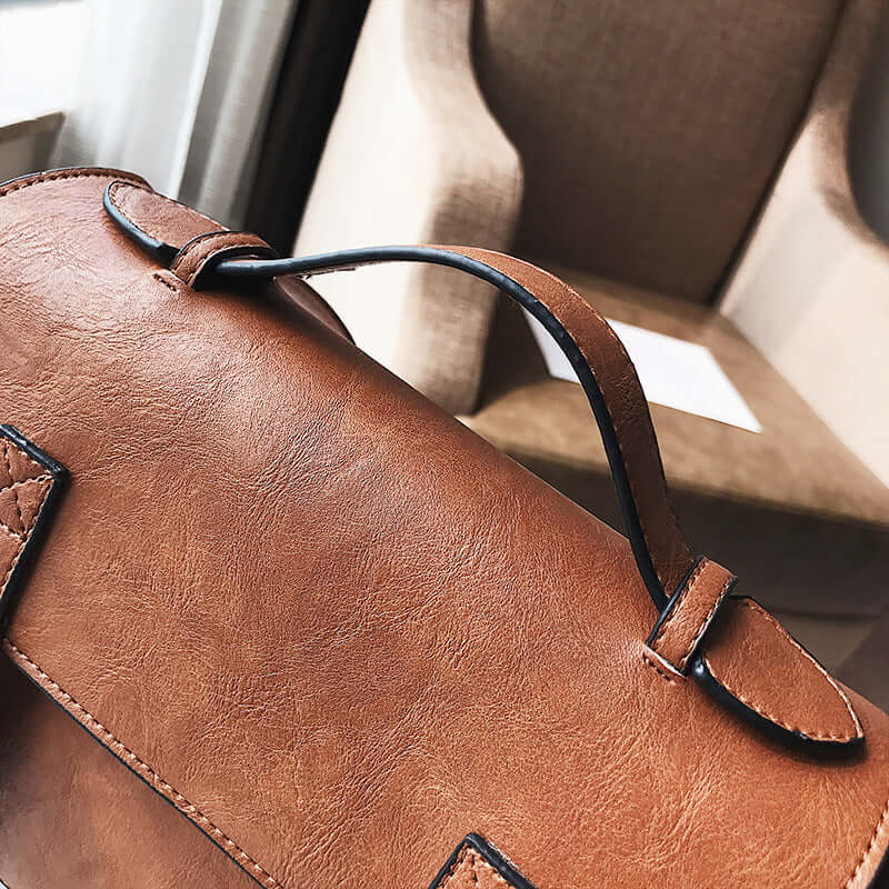 Stylish messenger bag and commuter bag in brown PU leather with smooth fabric lining, perfect for modern women.
