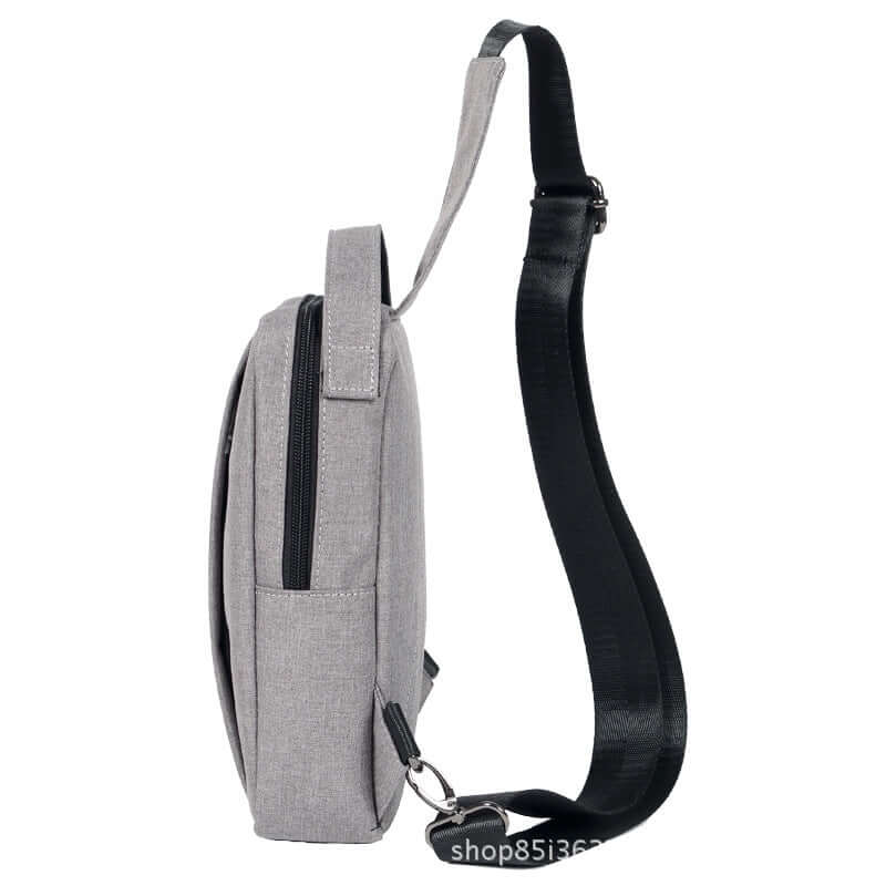 Side view of a stylish gray chest crossbody shoulder bag featuring an adjustable strap and open zipper.