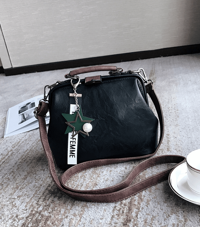 Chic doctor shoulder bag featuring a retro aesthetic, crafted from durable PU material, displayed with a cup and magazine.